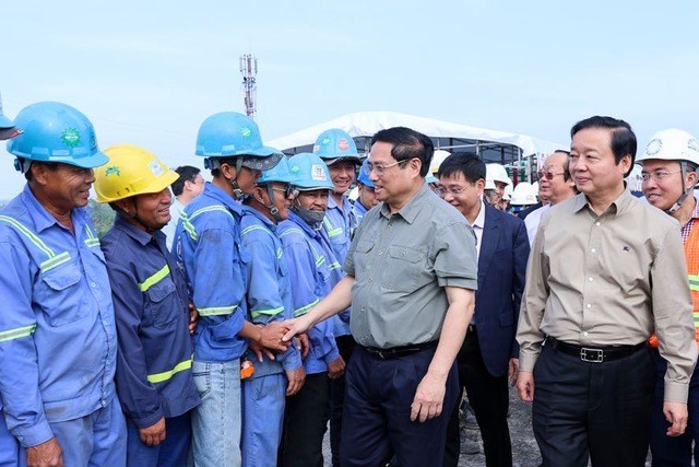 Премьер-министр Фам Минь Тьинь разговаривает с рабочими на строительной площадке моста Митхуан 2. Фото: VGP