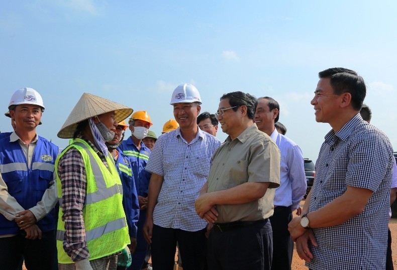 Премьер-министр Фам Минь Тьинь разговаривает с рабочими на строительной площадке. 