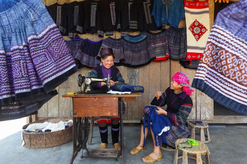 Девушки народности Хмонг занимаются шитьем в культурном пространстве.