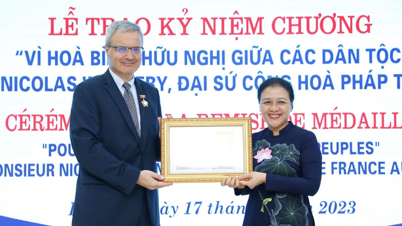 Посол Нгуен Фыонг Нга вручает памятную медаль Послу Франции во Вьетнаме Николя Уорнери. Фото: ВИА