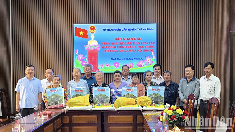 Замначальника Постоянного представительства газеты «Нянзан» в г. Канхо Зыонг Хонг Лам вручает подарки жителями провинции Донгтхап.