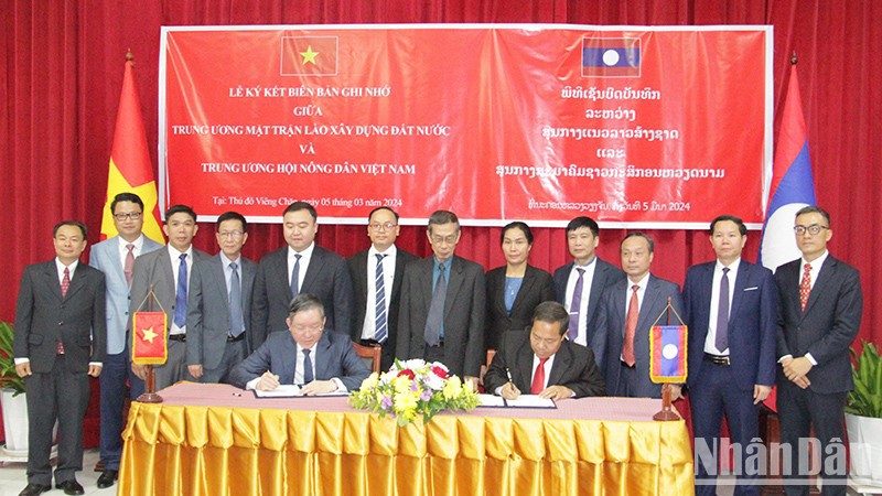 Центральное правление Общества фермеров Вьетнама и ЦК Фронта национального строительства Лаоса подписывают документ о сотрудничестве. 