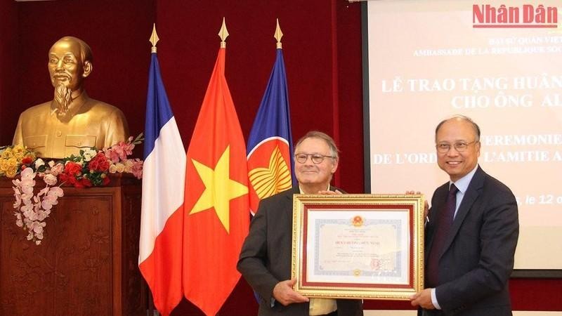 Посол Вьетнама во Франции Динь Тоан Тханг вручает Медаль Дружбы историку Алену Руссио. Фото: Кхай Хоан
