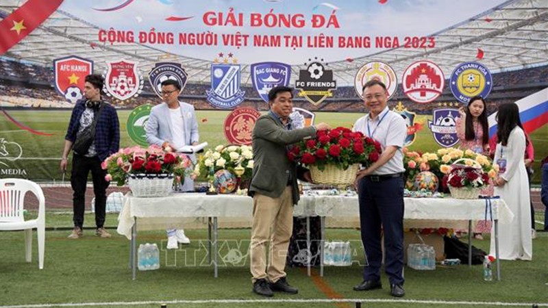 Советник-посланник Посольства Вьетнама в России Ле Куанг Ань (справа) дарит цветы оргкомитету. Фото: ВИА