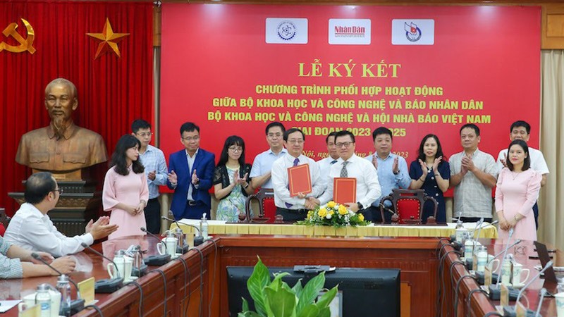 Главный редактор Ле Куок Минь и Министр науки и технологий Хюинь Тхань Дат подписывают Программу. 