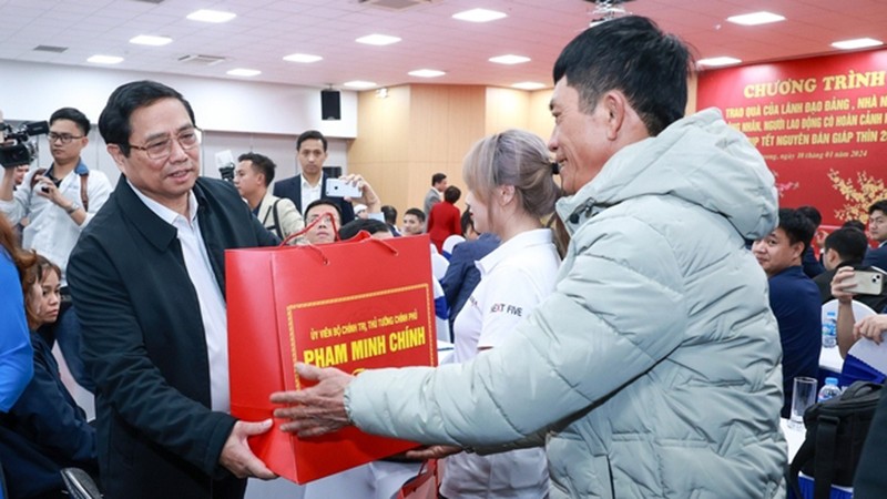 Премьер-министр Фам Минь Тьинь вручает подарки трудящимся, находящимся в трудной ситуации, в компании Kefico при корпорации Hyundai Motor в провинции Хайзыонг, 10 января. Фото: VGP