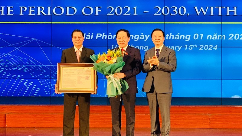 Вице-премьер Чан Хонг Ха вручает руководителям города Хайфона решение об утверждении плана развития города. 