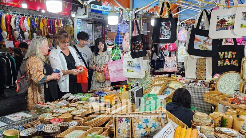 Иностранные туристы с удовольствием покупают вьетнамские сувениры на ночном рынке Старого квартала Ханоя. Фото: Т. Линь