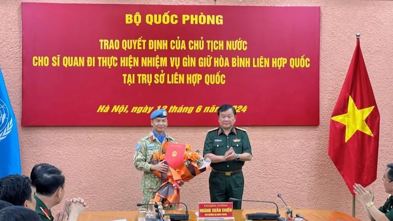 Генерал-полковник Хоанг Суан Тьиен вручает решение полковнику Чыонг Ань Туану. 