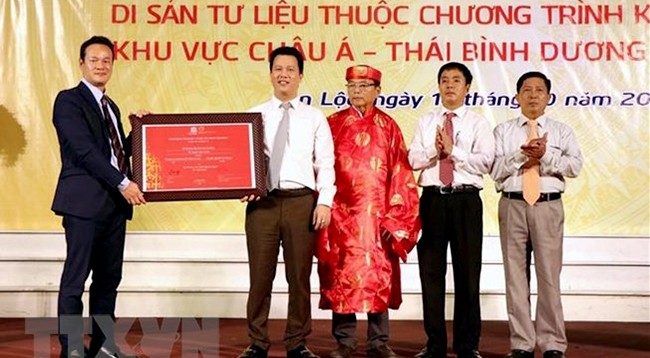 Генеральный секретарь ЮНЕСКО во Вьетнаме Май Фан Зунг вручает сертификат руководителю провинции Хатинь и представителю рода Нгуен Хюи. Фото: VNA