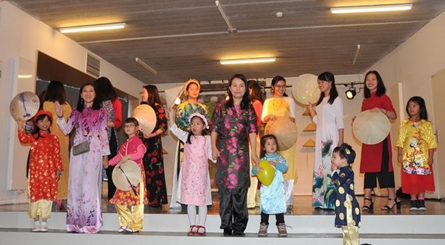 Выступление представителей вьетнамской диаспоры в платьях аозай. Фото: VNA