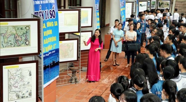 Ученики спецшколы имени Ле Хонг Фона провинции Намдинь изучают материалы, представленные на выставке. Фото: VNA