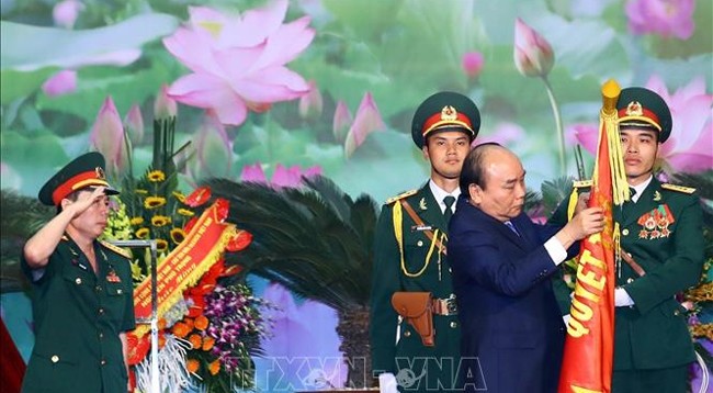 Премьер-министр Нгуен Суан Фук вручает Решение и прикрепляет Орден Защиты Отечества 1-й степени на боевое знамя соединения № 12. Фото: VNA