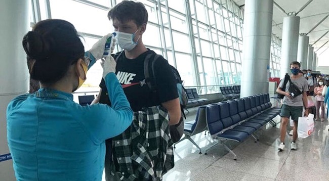 Пассажиры проходят медосмотр перед посадкой в самолет.