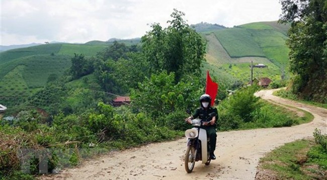 Сотрудник пограничной заставы Тьиенгон в провинции Шонла ездит на мотоцикле по селениям для пропаганды об эпидемии COVID-19. Фото: VNA