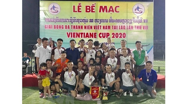 Представители Посольства Вьетнама в Лаосе и Оргкомитета вручают 1-й приз команде «FC Бонфыонг». Фото: VNA
