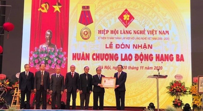 Товарищ Чан Тхань Ман вручает Вьетнамской ассоциации ремесленных деревень орден труда 3-й степени. Фото: kinhtedothi.vn