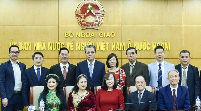 Замминистра иностранных дел Вьетнама Данг Минь Кхой фотографируется на память с лучшими вьетнамцами, проживающими за границей, на встрече. Фото: baoquocte.vn