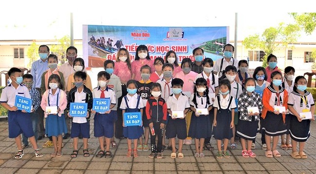 Представители газеты «Нянзан» в г. Кантхо и Бизнес-ассоциации провинции Камау вручают стипендии ученикам. Фото: Хыу Тунг