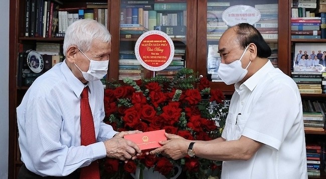 Президент Нгуен Суан Фук вручает подарок журналисту Данг Минь Фыонгу. Фото: VNA