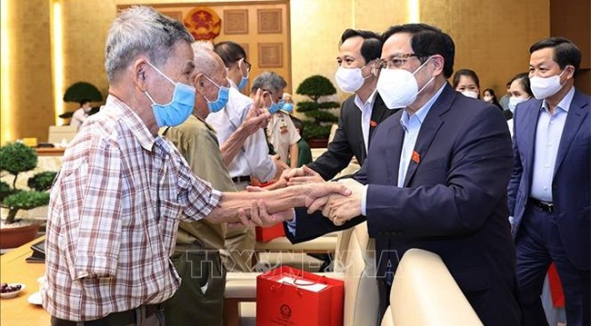 Премьер-министр Фам Минь Тьинь встречается с людьми, имеющими заслуги перед Революцией. Фото: VNA