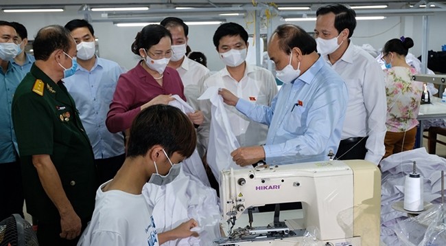 23 июля Президент Нгуен Суан Фук навестил швейное предприятие в провинции Ханам, владельцем которого является инвалид войны Хоанг Ван Туен. Фото: Дао Фыонг