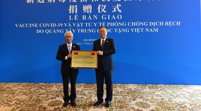 Посол Вьетнама в Китае Фам Шао Май (слева) принимает товары. Фото: VNA