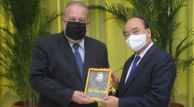 Президент Вьетнама (справа) дарит Премьер-министру Кубы книгу «Фидель Кастро Рус – великий международный революционер». Фото: VNA