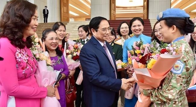 Премьер-министр Фам Минь Тьинь и делегаты-женщины. Фото: Чан Хай
