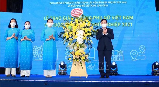 Вице-премьер Фам Бинь Минь дарит поздравительные цветы Союзу женщин Вьетнама. Фото: VNA