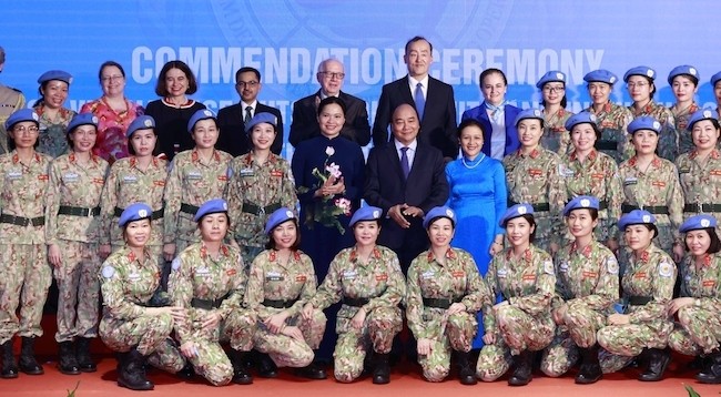 Президент Нгуен Суан Фук и представители коллективов и отдельные лица, которые участвуют в миротворческой деятельности ООН. Фото: VGP