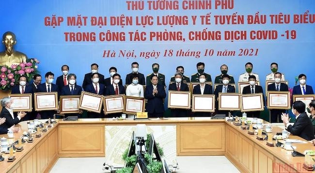 Премьер-министр Фам Минь Тьинь и лучшие представители медицинских сил на фронте борьбы с эпидемией. Фото: Чан Хай