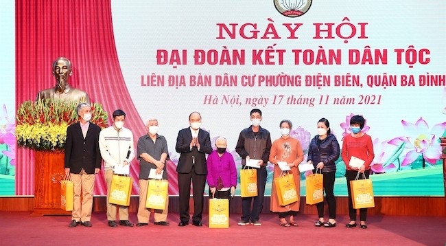 Президент Нгуен Суан Фук вручает подарки представителям семей, находящихся в трудной жизненной ситуации. Фото: VNA
