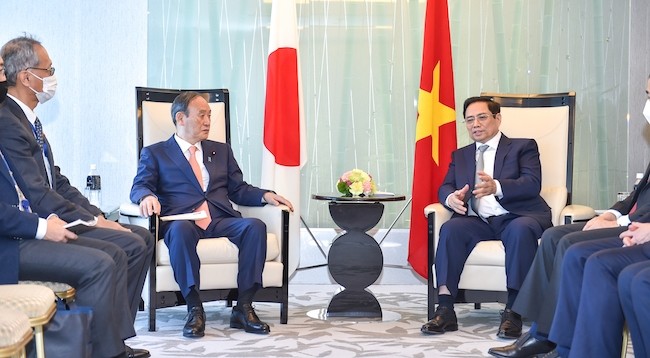 Премьер-министр Фам Минь Тьинь (справа) принимает бывшего Премьер-министра Японии Сугу Ёсихидэ. Фото: VGP