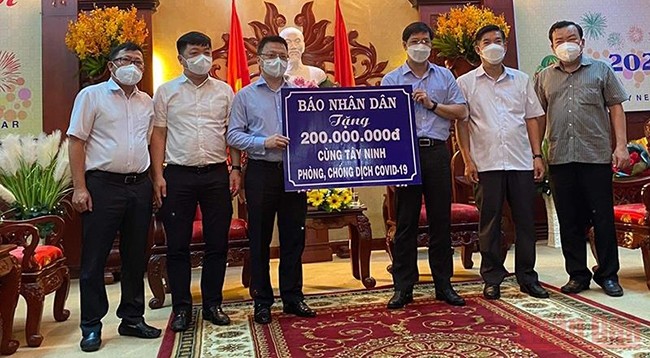 От имени газеты «Нянзан» товарищ Ле Куок Минь вручает 200 млн вьетнамских донгов для поддержки Тэйнинь в профилактике и борьбе с эпидемией Covid-19.