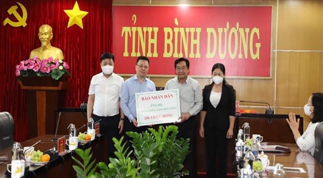 Товарищ Ле Куок Минь вручает 200 млн донгов от газеты «Нянзан» для поддержки провинции Биньзыонг в борьбе с эпидемией Covid-19.