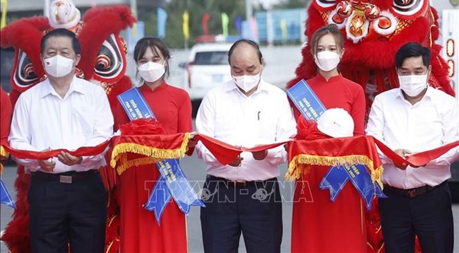 Президент Нгуен Суан Фук и делегаты разрезают ленту в знак открытия движения по главной дороге скоростной автомагистрали Чунглыонг – Митхуан. Фото: VNA