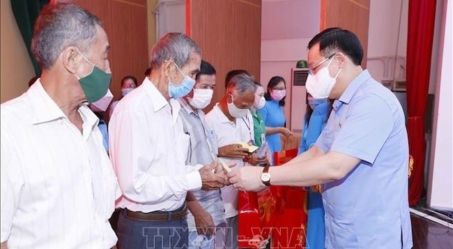 Председатель НС Выонг Динь Хюэ вручает подарки представителям семей льготной категории. Фото: VNA