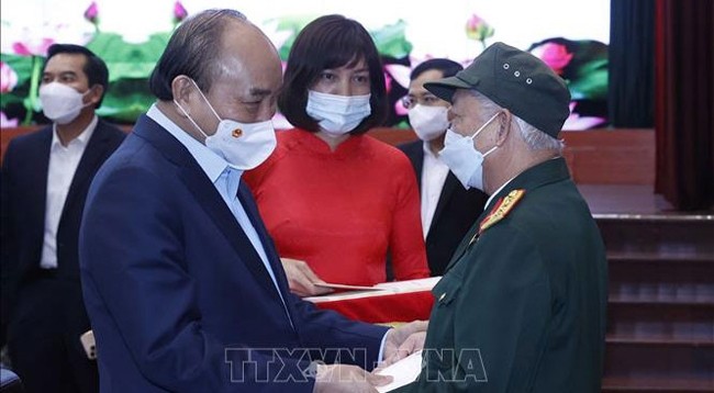 Президент Вьетнама Нгуен Суан Фук вручает подарки людям льготной категории. Фото: VNA