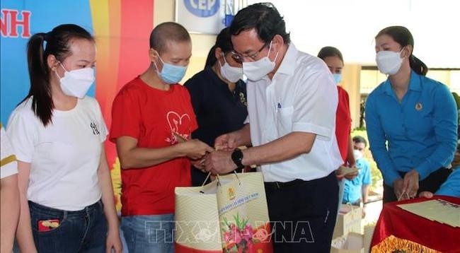 Секретарь Парткома г. Хошимина Нгуен Ван Нэн вручает подарки рабочим в провинции Донгнай. Фото: VNA