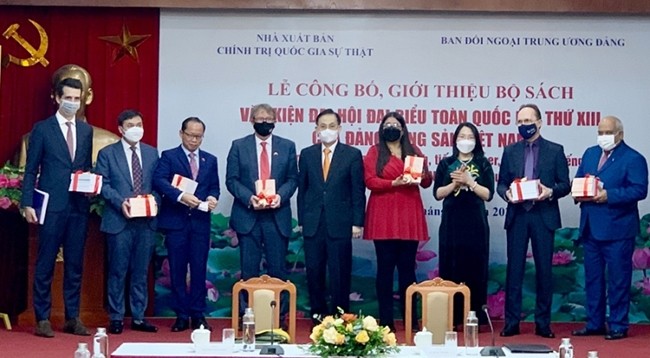Товарищ Ле Хоай Чунг вручает сборник книг послам, заместителям послов, поверенным в делах зарубежных дипломатических представительств во Вьетнаме.