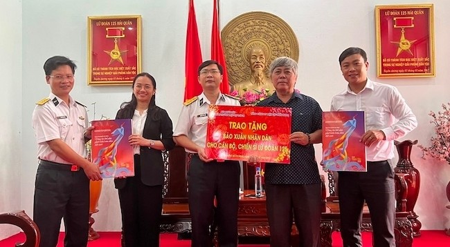 Представители газеты «Нянзан» и Южной электроэнергетической корпорации Вьетнама вручают весенние издания «Нянзан» 125-й бригаде.