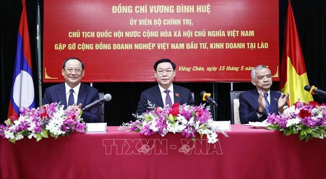 Председатель НС Выонг Динь Хюэ (в центре) на встрече с представителями вьетнамских деловых кругов в Лаосе. Фото: VNA