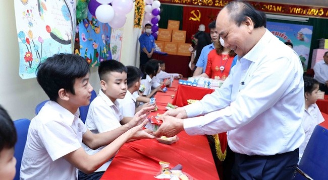 Президент Нгуен Суан Фук вручает подарки детям с ограниченными возможностями. Фото: VNA