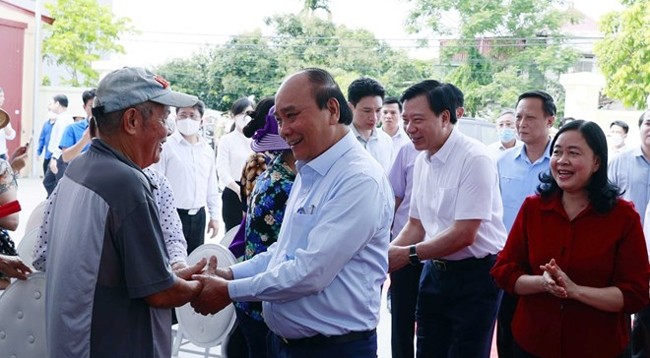 Президент Нгуен Суан Фук разговаривает с членами кооператива Танминьдык. Фото: VNA