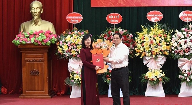 Премьер-министр Фам Минь Тьинь вручает решение товарищу Дао Хонг Лан.