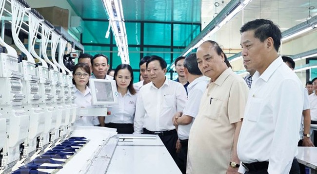 Президент Нгуен Суан Фук посещает цехи по производству текстильно-швейных изделий компании «Шаомай». Фото: VNA 