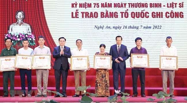 Председатель НС Выонг Динь Хюэ вручает грамоты «За заслуги перед Отечеством» родственникам семей павших бойцов. Фото: VNA