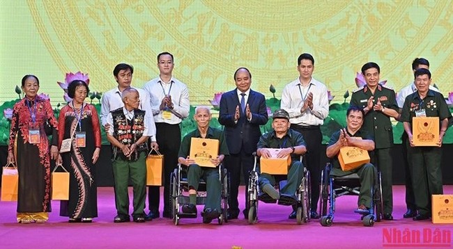 Президент Нгуен Суан Фук вручает подарки представителям лиц, имеющих заслуги перед революцией. Фото: Данг Кхоа