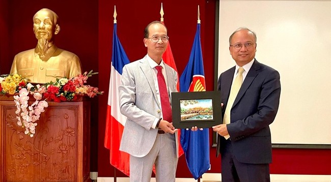 Представитель Центра сохранения памятников г. Хюэ вручает памятный подарок Послу Вьетнама во Франции Динь Тоан Тхангу (справа). Фото: Минь Зюи